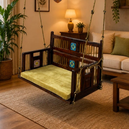 A dark wooden hanging swing chair with a light green cushion, suspended by chains in a warm, modern living room setting.